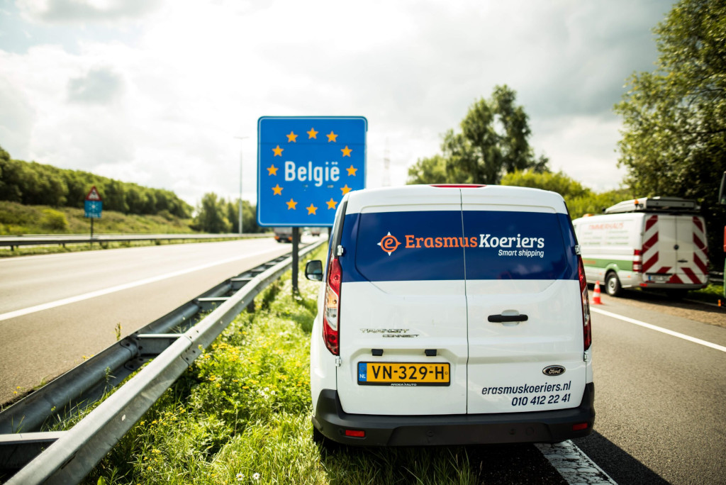 Auto van Erasmus Koeriers staat bij de grens tussen Nederland en België. Direct internationale diensten Erasmus Koeriers